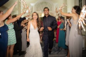 Tampa Bay Bride and Groom Wedding Exit with Gold and White Streamers, Bride in Hayley Paige Fit and Flare Wedding Dress, Groom Wearing Traditional Punjabi | Florida Historic Wedding Venue The Don CeSar in St. Pete Beach
