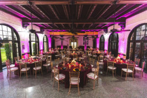 Boho Chic Wedding Reception Decor, Pink Uplighting, Round Tables with Merlot Linens, Gold Chiavari Chairs, Gold Chargers | St. Petersburg Wedding Reception Venue Admiral Ferragut Academy | Wedding Linens and Caterer Olympia Catering & Events