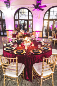 Boho Chic Wedding Reception Decor, Round Tables with Velvet Merlot Linens, Gold Chiavari Chairs, Gold Chargers, Pink Uplighting | St. Petersburg Wedding Reception Venue Admiral Ferragut Academy | Tampa Wedding Caterer and Linens Olympia Catering & Events