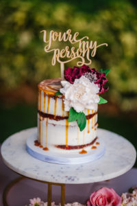 Two Tier Semi Naked Wedding Cake with Caramel Drizzle and White and Purple Flowers and Laser Cut Custom Cake Topper