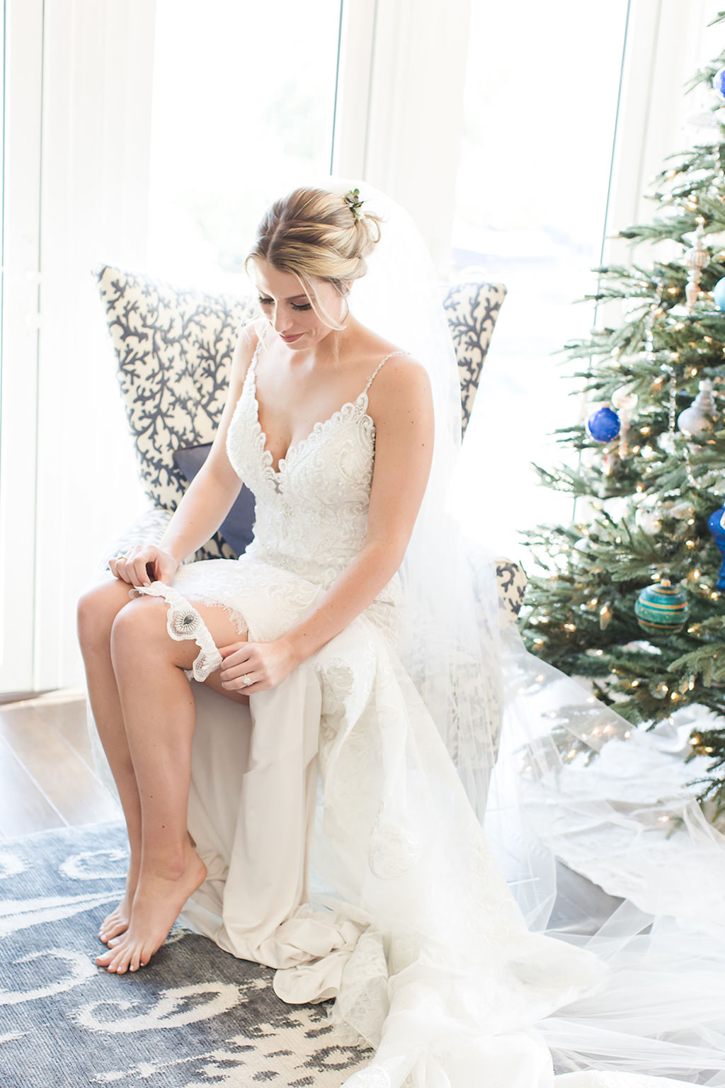 Florida Bride Getting Ready Photo in Allure Wedding Dress, Pulling Up Lace Garter, Christmas | Tampa Bay Wedding Photographers Shauna and Jordon Photography
