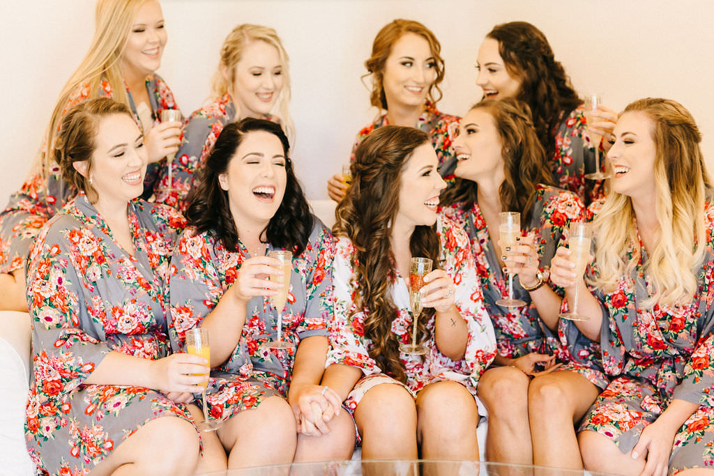Florida Bride and Bridesmaids in Matching Gray and Blush Pink Floral Silk Robes, Bridal Party Drinking Mimosas Getting Wedding Ready Portrait
