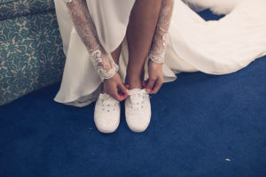 Florida Bride Getting Ready Wedding Portrait, Putting on Silver Glitter Sparkle Kate Spade Tennis Shoes | Tampa Bay Luxury Wedding Photographer Luxe Light Images
