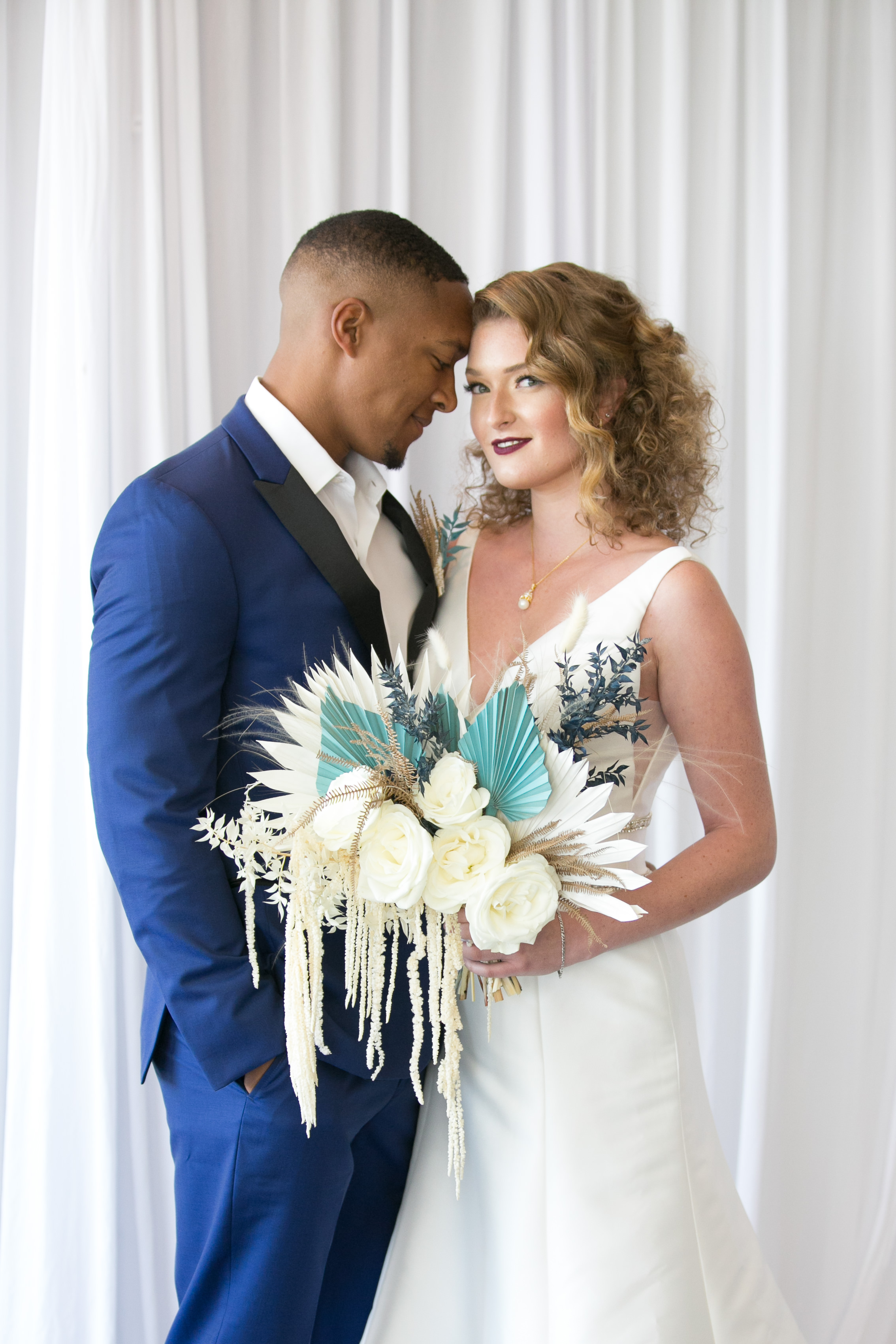 Classic Bride and Groom Beauty Wedding Portrait in A-Line V Neck Wedding Dress Holding Unique White Roses, Ivory and Greenery Floral Accent Bridal Bouquet, Groom in Blue Suit | Tampa Bridal Wedding Dress Boutique Truly Forever Bridal | South Tampa Bridal Hair and Makeup Michele Renee the Studio | Wedding Planner and Florist John Campbell Weddings