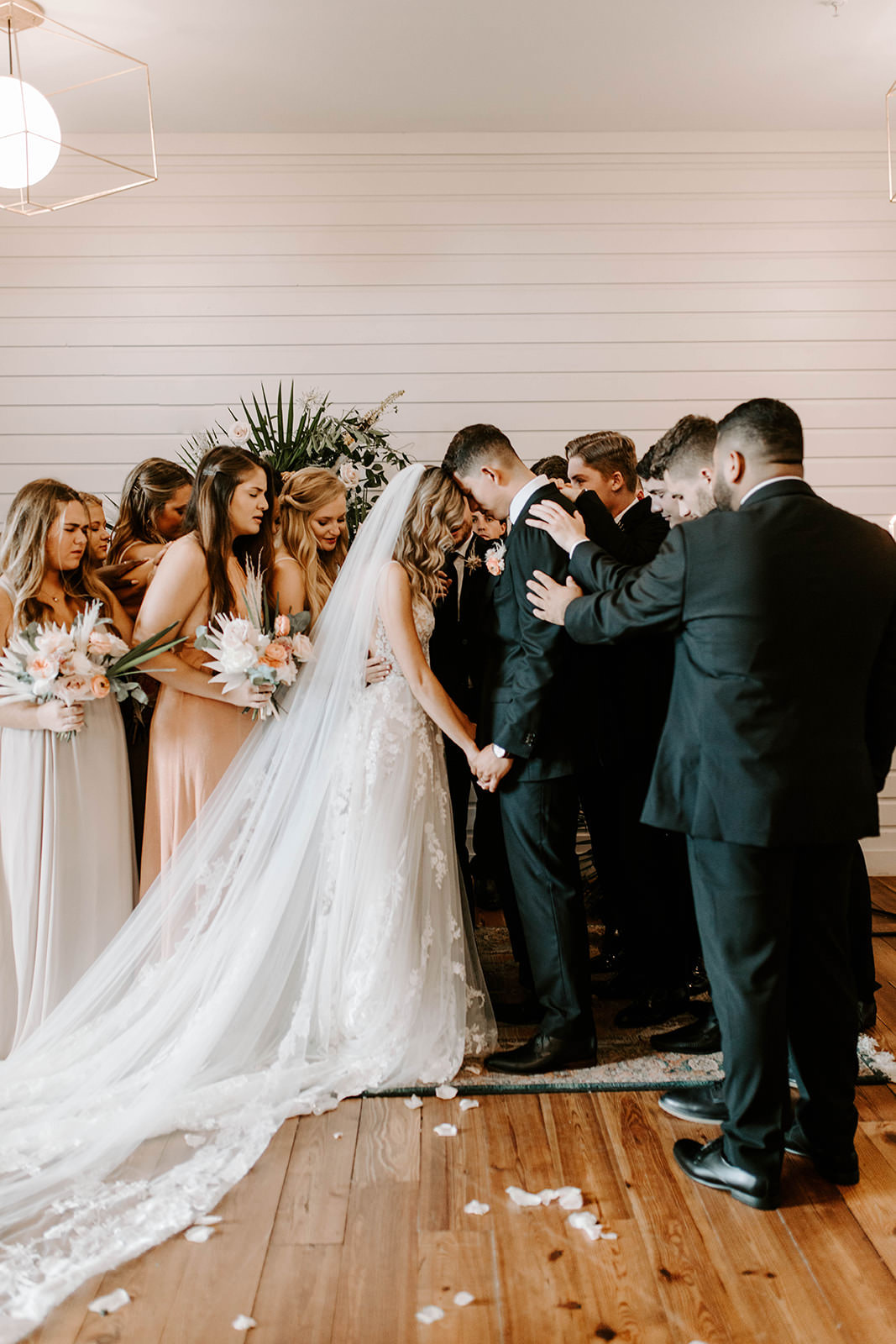 Boho Whimsical Bride and Groom Praying During Wedding Ceremony Portrait with Wedding Party | Tampa Bay Industrial Wedding Venue Armature Works