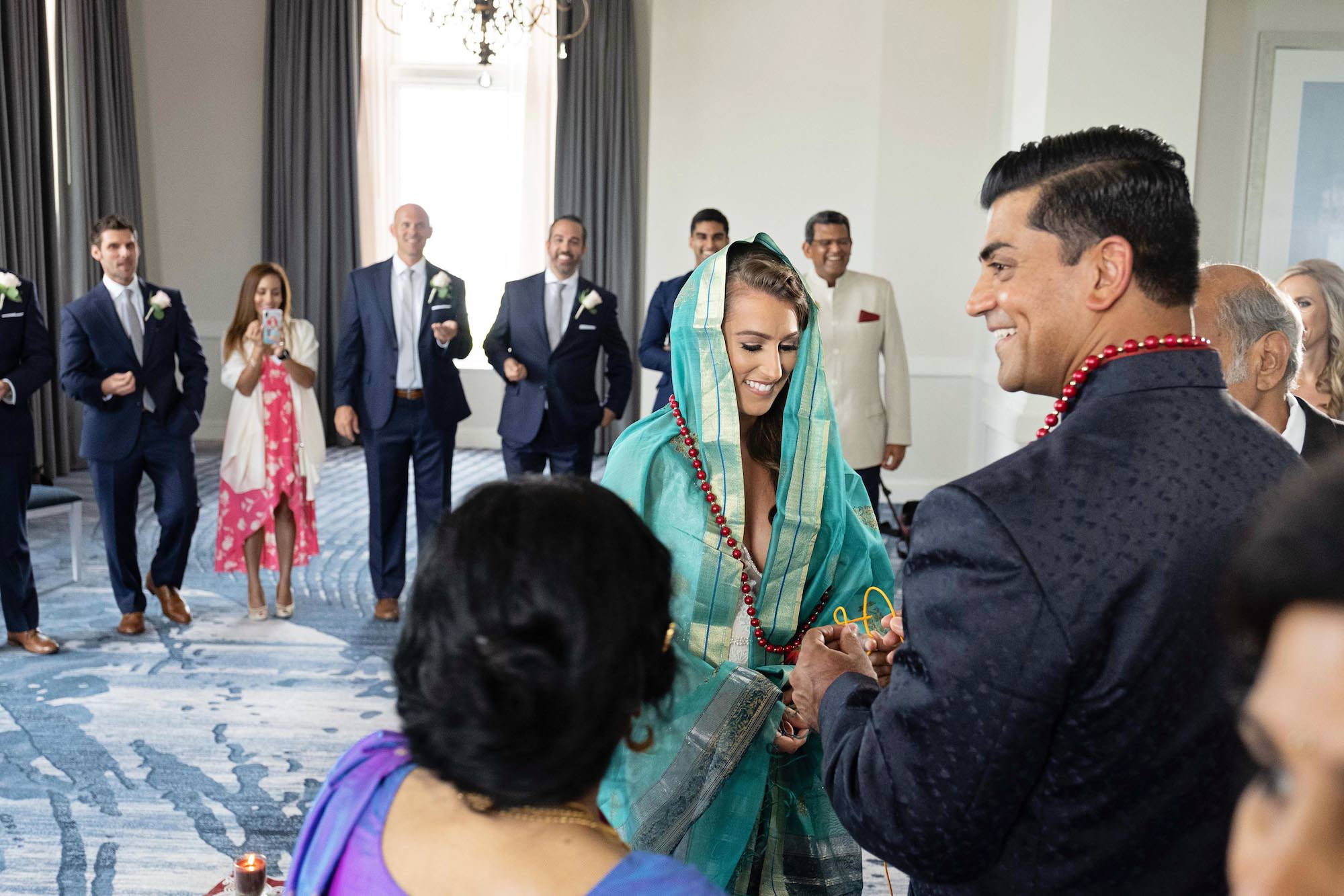 Florida Bride and Groom in Intimate Religious Hindu Wedding Ceremony, Bride Wearing Brightly Colored Teal Sari, Wearing Red Beads, | The Don CeSar Resort in Tampa Bay