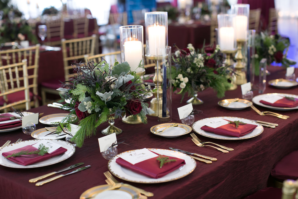 Christmas Inspired Wedding Reception Decor, Burgundy Linens, Gold Flatware, Greenery Low Floral Centerpieces Gold Candle Holders | Tampa Bay Wedding Photographer Carrie Wildes Photography