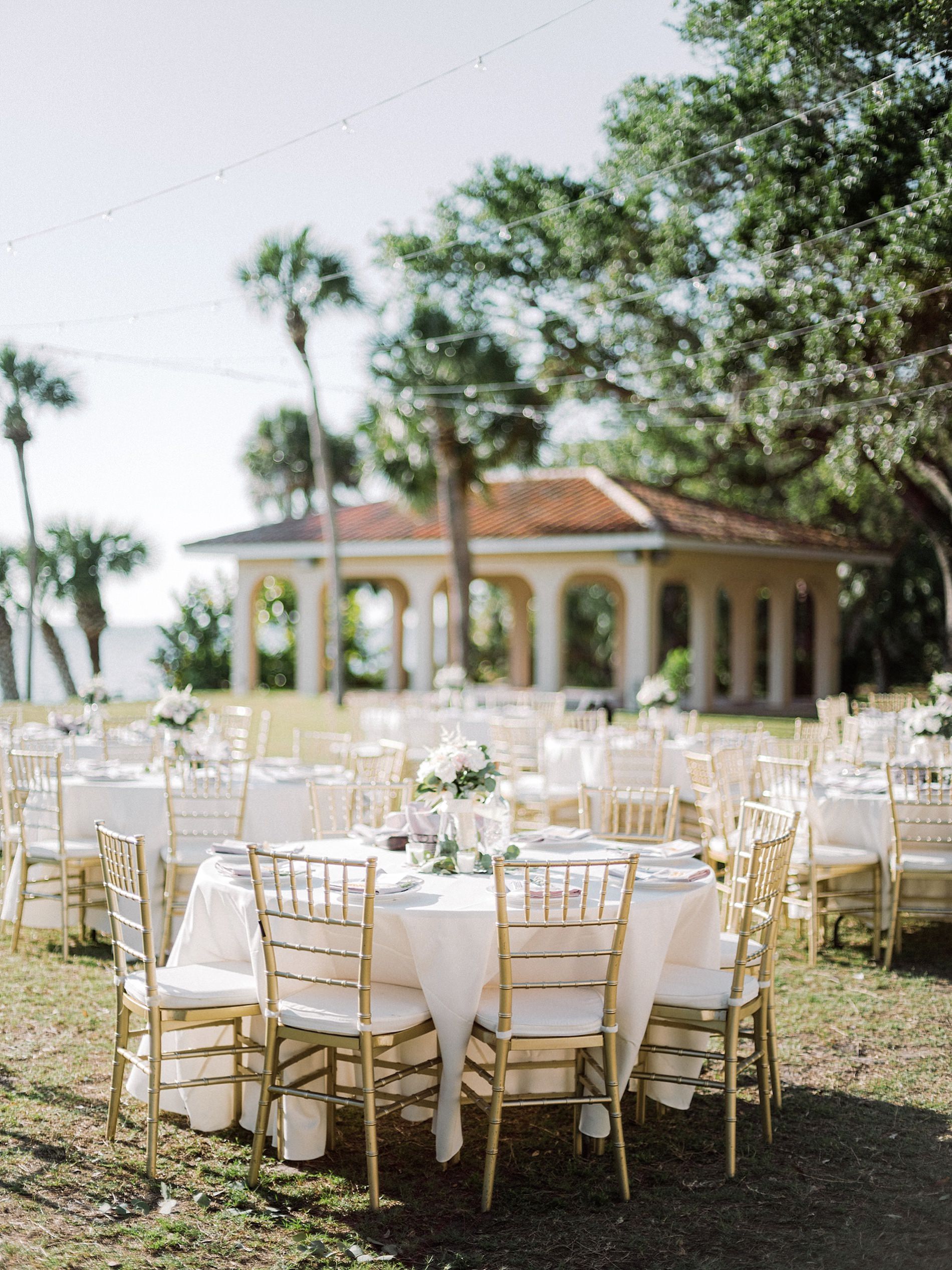 Romantic Elegant Outdoor Garden Wedding Reception Decor, Round Tables with White Tablecloths, Gold Chiavari Chairs and Low Floral Centerpieces | Sarasota Wedding Venue Powel Crosley Estate
