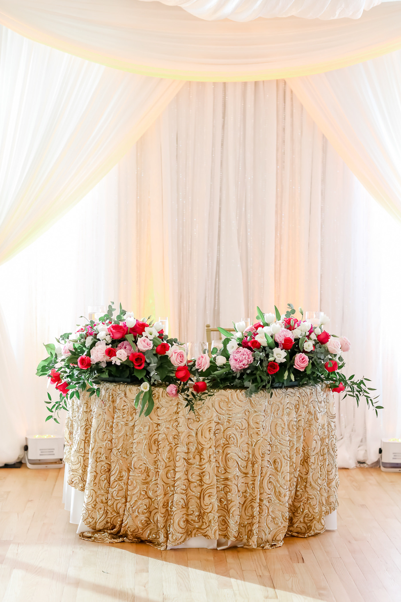Wedding Reception Decor, Sweetheart Table with Gold Swirl Sequins Linen, Pink, Blush and White Roses and Greenery Floral Arrangement with White Backdrop Draping | Tampa Bay Wedding Photographer Lifelong Photography Studios | Wedding Rentals Over the Top Linens
