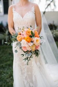 Romantic Whimsical Bride in Lace Watters with Illusion Neckline Wedding Dress Holding Blush Pink and Orange Roses, Dusty Miller Leaves, Greenery Floral Bridal Bouquet | Tampa Bay Wedding Florist Bruce Wayne Florals