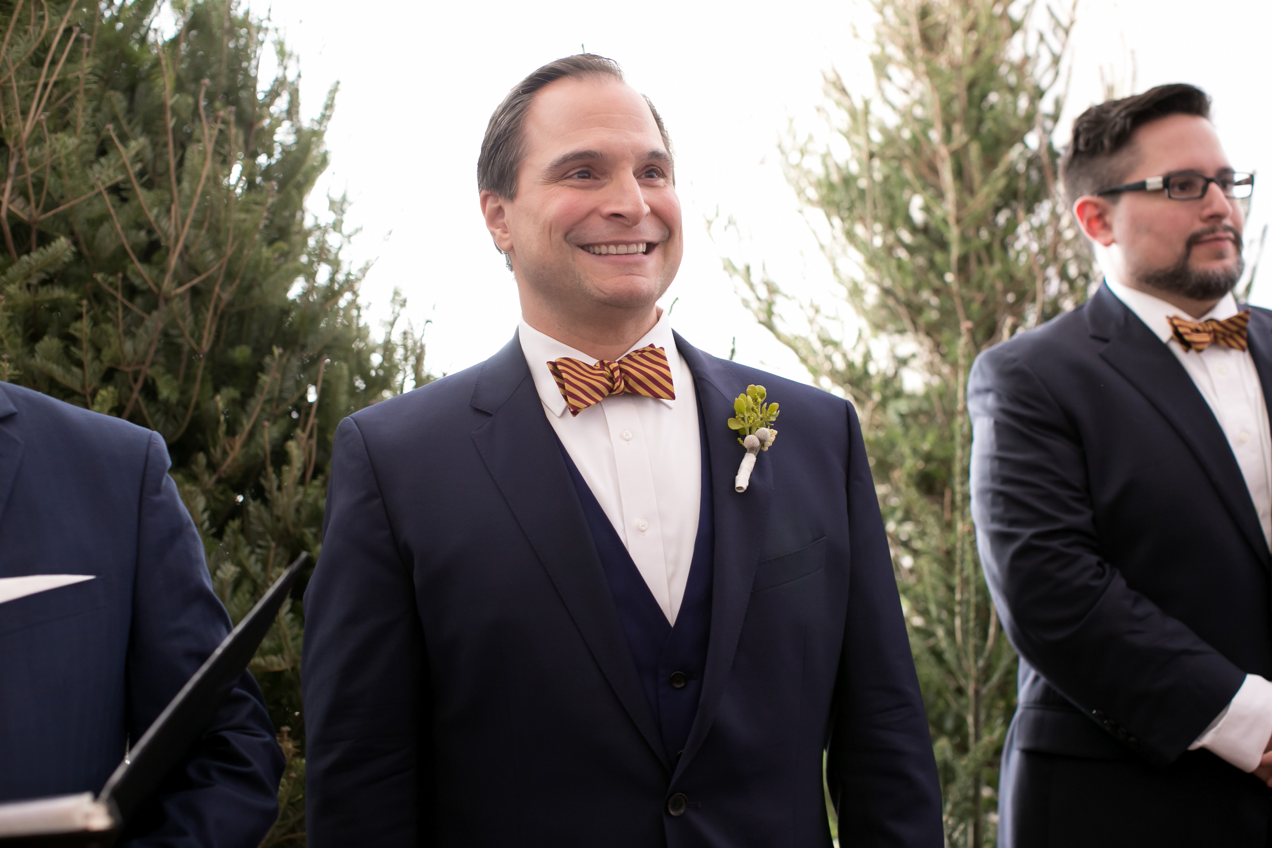 Florida Groom Excited Happy Reaction to Bride Walking Down the Aisle Wearing Navy Blue Suit with Striped Yellow and Burgundy Bowtie | Tampa Bay Wedding Photographer Carrie Wildes Photography