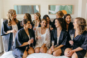 Florida Classic Bride with Bridesmaids in Matching Navy Blue Robes and Champagne Portrait | Tampa Bay Hair and Makeup Femme Akoi Beauty Studio