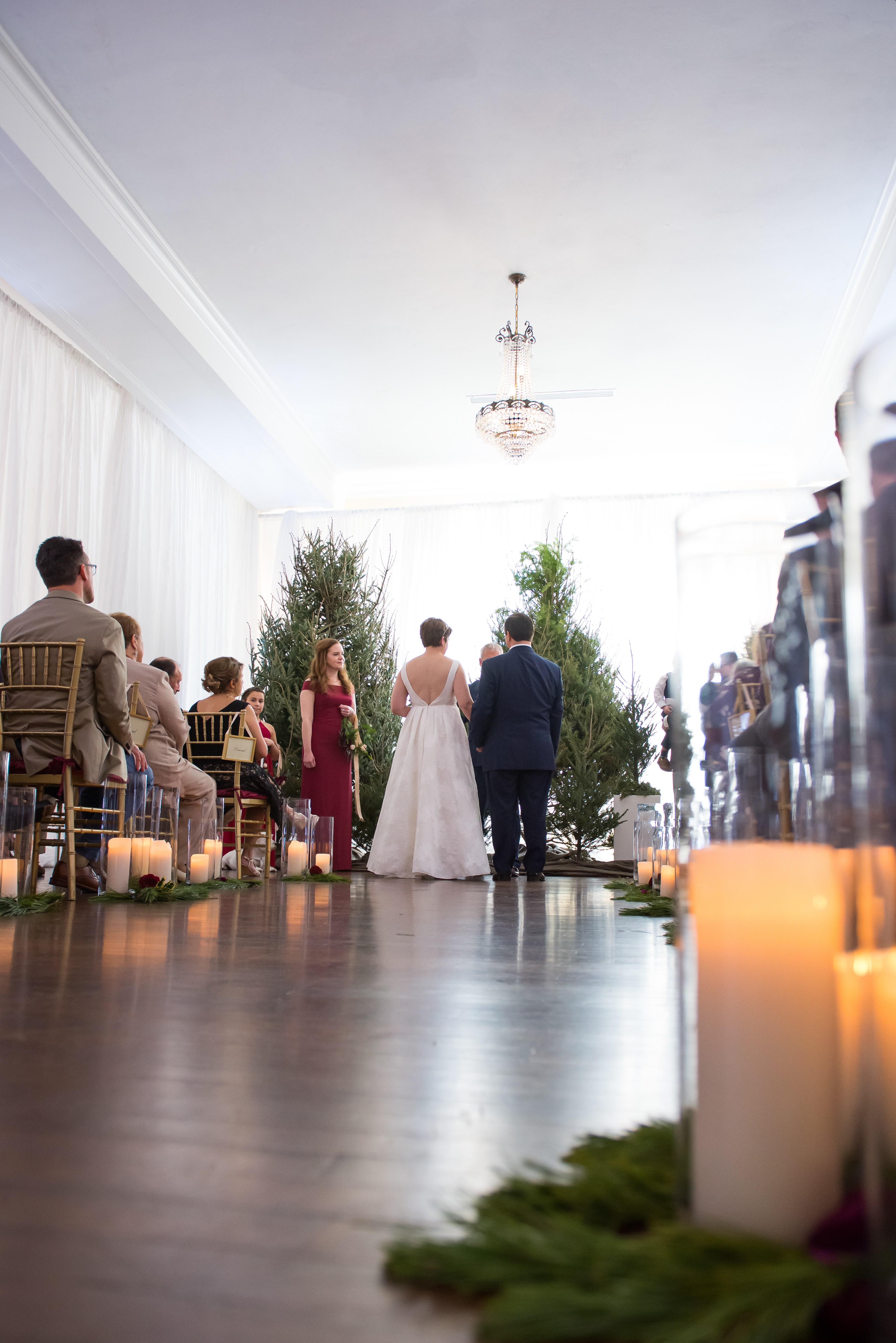 Christmas Wedding Ceremony Decor, Bride and Groom Exchanging Wedding Vows, Christmas Trees at Altar | Tampa Bay Wedding Photographer Carrie Wildes Photography | South Tampa Wedding Venue The Orlo House