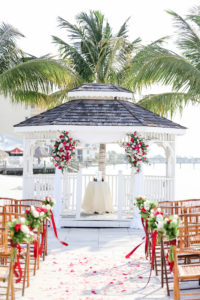 Tropical Wedding Ceremony Decor, White Gazebo with Pink, White and Greenery Floral Arrangements, Wooden Bamboo Chairs | Tampa Bay Wedding Photographer Lifelong Photography Studios | St. Pete Waterfront Wedding Venue Isla Del Sol Yacht and Country Club | Wedding Rentals A Chair Affair