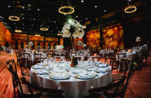 Classic Wedding Reception and Decor, Tall Elegant Centerpieces with Large White Floral Design, on Round Tables with White Lines, Farmhouse Cross Back Chairs, In The Gathering Ballroom At Armature Works in Tampa Heights | Downtown Tampa Wedding Planner Coastal Coordinating | Tampa Bay Entertainers Bay Kings Band