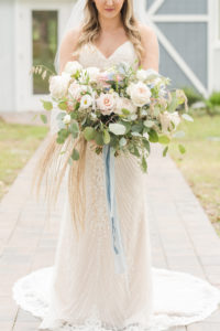 Florida Bride Holding Vintage Meets Rustic Bridal Bouquet with Light Pink Roses, Ivory Flowers, Dusty Rose Florals, Eucalyptus Leaves and Greenery, Pompous Grass, Dusty Blue Ribbon, Wearing Romantic Beaded Wedding Dress | Tampa Bay Wedding Planner Elegant Affairs by Design