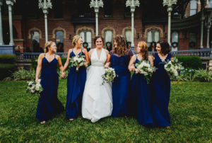 Florida Bride and Bridesmaids, Wearing Romona Keveza Wedding Dress, Bridesmaids in Hayley Paige Occassions Long Mix Matched Navy Blue Dresses, Holding White, Ivory and Silver Floral Bouquets with Greenery | Tampa Bay Wedding Planner Coastal Coordinating | South Tampa Bridesmaids Dress Boutique Bella Bridesmaids | Tampa Luxury Wedding Dress Shop Isabel O'Neil Bridal Collection | University of Tampa