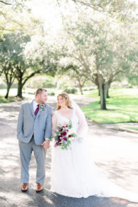 Rustic Bride in V Neckline Lace A-Line Wedding Dress Holding Organic Greenery Pink, Purple, White Floral Bouquet, Groom in Gray Suit with Maroon Tie Wedding Portrait | Tampa Bay Wedding Photographer Shauna and Jordon Photography | Largo Wedding Venue The Bayou Club