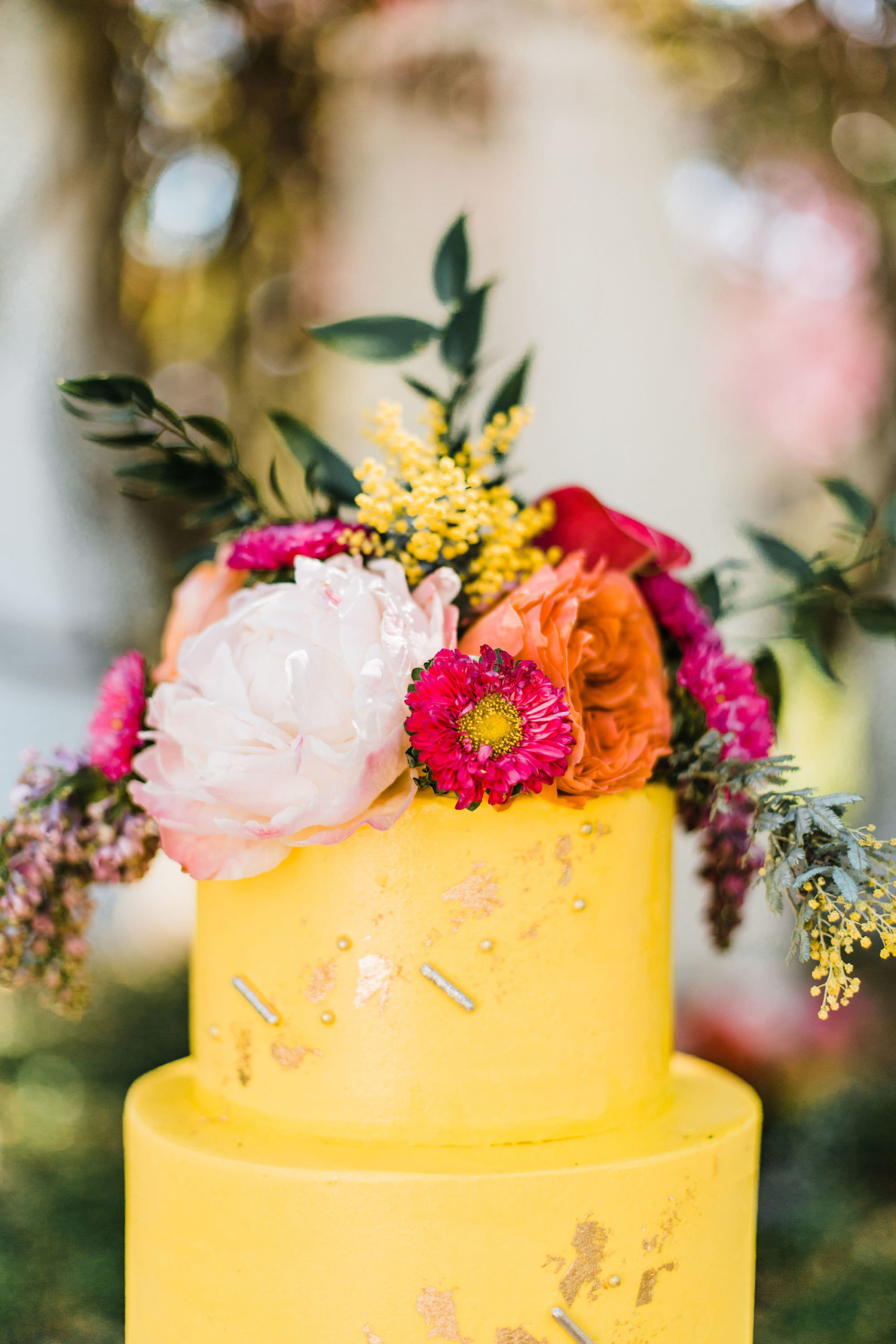 Yellow with Gold Metallic Accent Two Tiered Cake with Tropical Inspired Flowers | Wandering Whisk Bakeshop