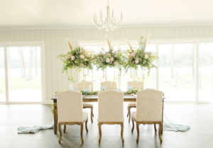 Dusty Rose Styled Wedding Shoot, Antique Off White Ivory Chairs, Wood Table with Tall Gold Frame Stands, Greenery, Blush Pink and White Roses, and Feather Floral Arrangements, Blue Wine Glasses | Tampa Bay Wedding Planner Elegant Affairs by Design | Odessa Rustic Waterfront Wedding Venue Barn at Crescent Lake