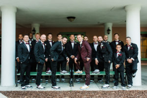 Groom in Burgundy Suit with White and Gold Sneakers, Groomsmen in Black Suits with Matching White and Black Sneakers and Burgundy Bowties Wedding Party Portrait