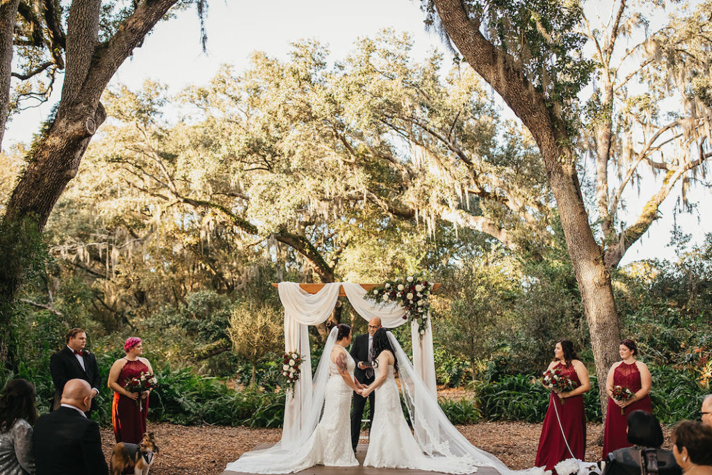 Rustic Country Fall Winter Outdoor Wedding Decor Draped Wood Ceremony Arch White Red and Greenery | Same Sex Florida Wedding Brides LGBTQ