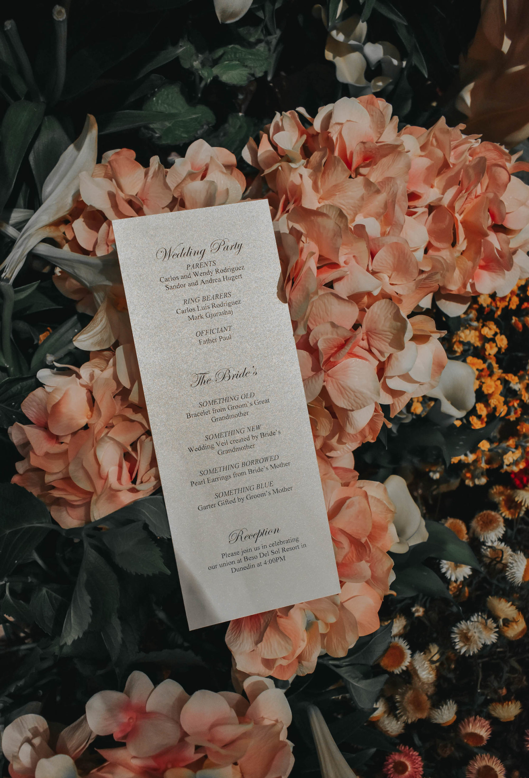 Classic Black and White Script Florida Wedding Ceremony Program, Sitting on Pink Floral Backdrop