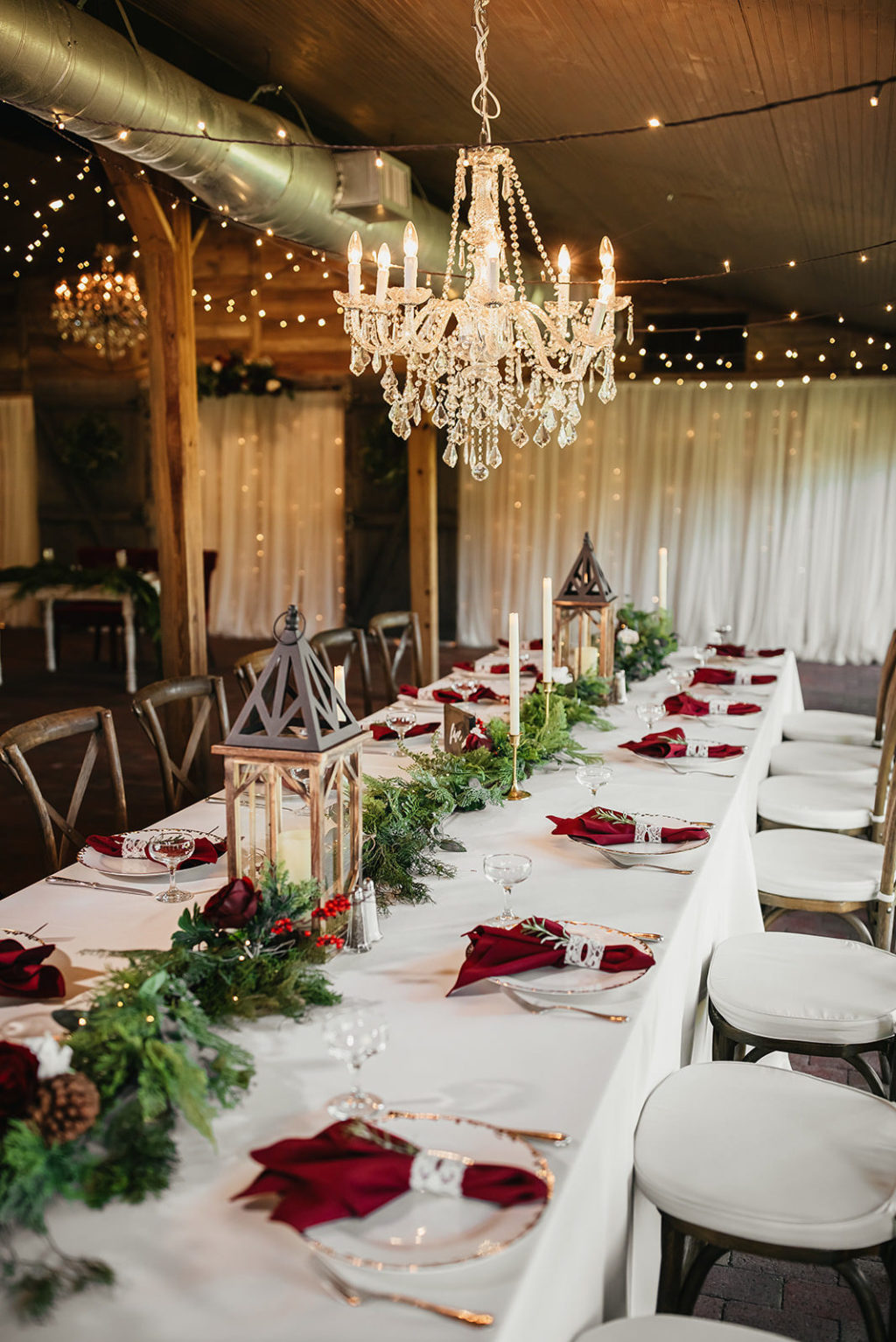 Rustic Country Fall Winter Barn Wedding | Greenery Garland Red Roses White Lanterns | Wood Cross Back Chairs | Gold Chargers and String Lights | Christmas Inspired Wedding Decor