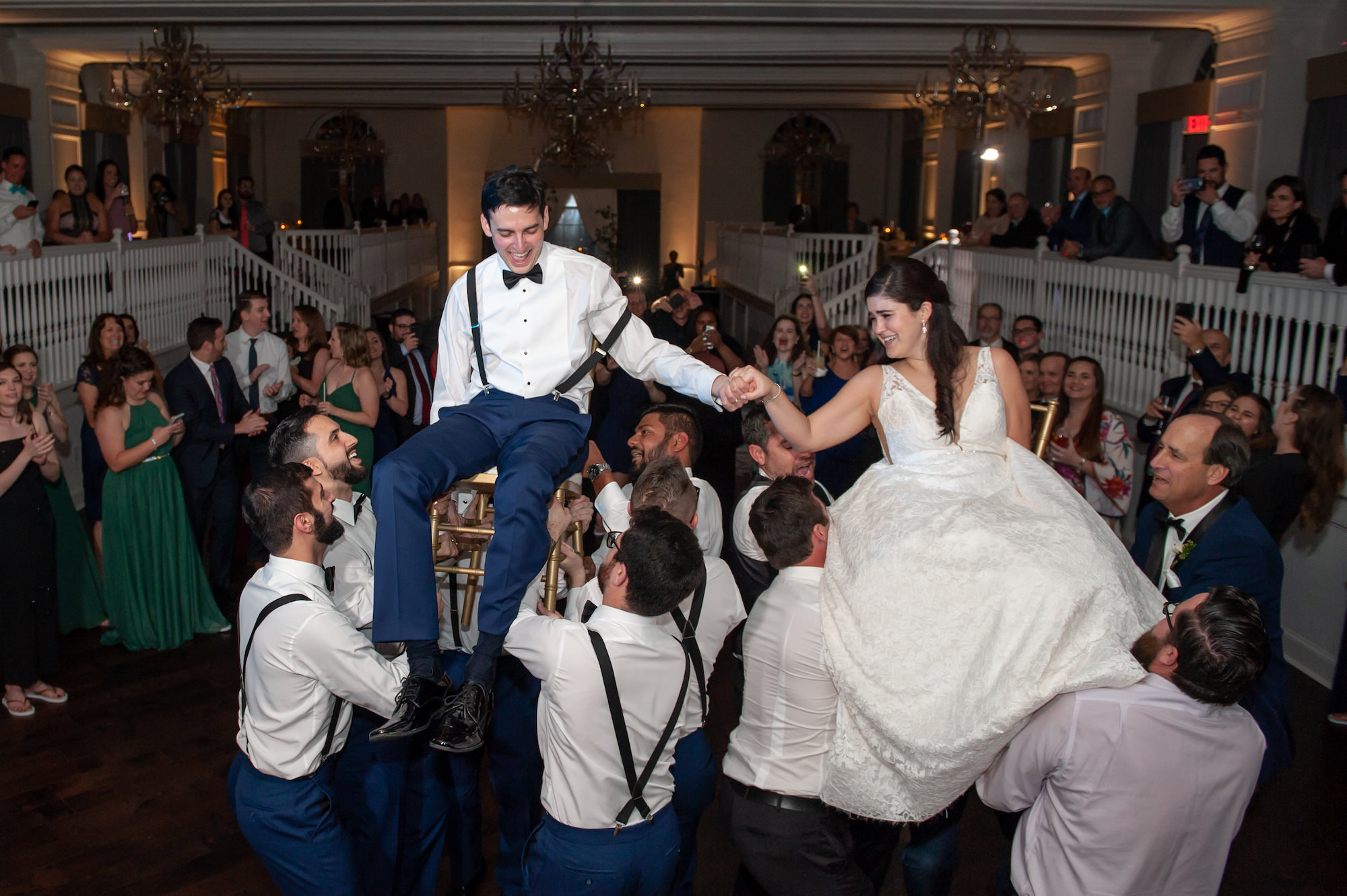 Fun Wedding Guests Lifting Bride and Groom in Chairs During Wedding Reception Dance | St. Petersburg Hotel Wedding Venue The Don CeSar, Historic Pink Palace | Jewish Wedding Reception