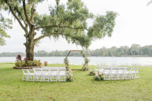 Florida Outdoor Waterfront Wedding Ceremony, Under Large Flowing Oak Tree, Rustic Wooden Hexagon Wedding Arch with Whimsical Inspired White and Dusty Rose and Pompous Grass Ceremony Flowers, White Chairs for Intimate Lakefront Ceremony | Tampa Bay Wedding Planner and Day of Coordinator Elegant Affairs by Design | Venue Barn at Crescent Lake