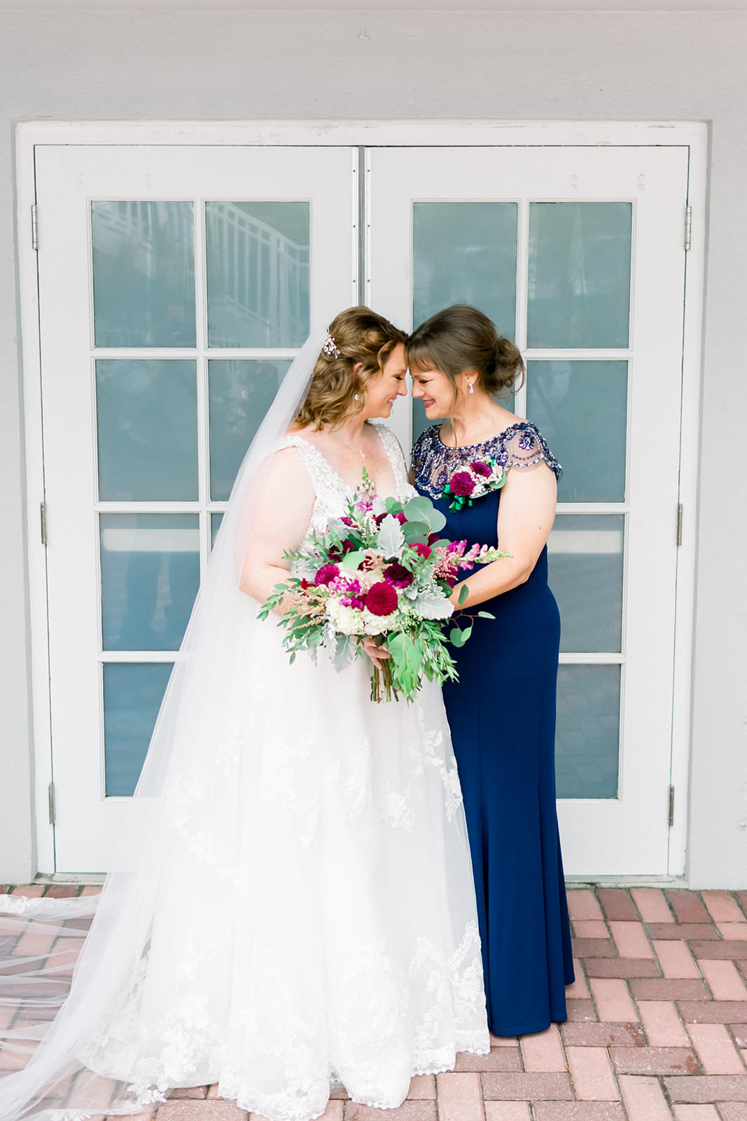 Beautiful Bride Holding Garden Greenery with Pink, Red and Purple Floral Bouquet and Mother Wedding Portrait | Navy Blue Mother of the Bride Dress | Tampa Bay Wedding Photographer Shauna and Jordon Photography