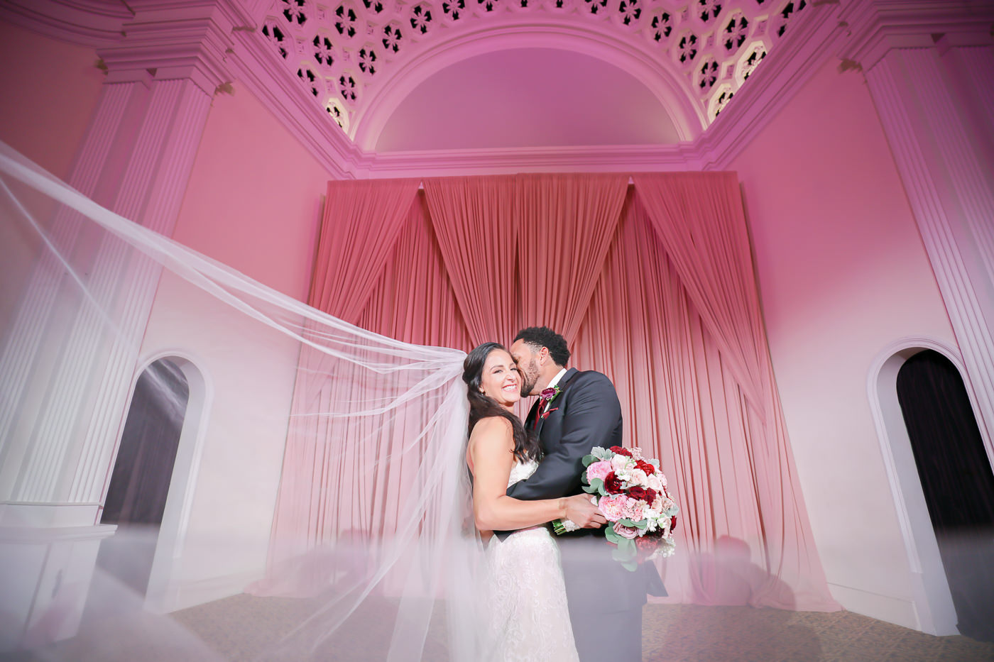 Creative Bride and Groom Wedding Portrait with Veil Blowing | Wedding Photographer Lifelong Photography Studios | Tampa Bay Wedding Planner Blue Skies Weddings and Events | St. Petersburg Wedding Venue Bridgepoint Church | Dusty Rose Draping Gabro Event Services