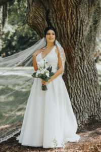 Florida Bride Wedding Portraits in Dunedin, Holding Greenery Inspired Bridal Bouquet with White Flowers, Wearing David's Bridal Halter Top A Line Wedding Dress | Tampa Bay Wedding Florist Brides N Blooms