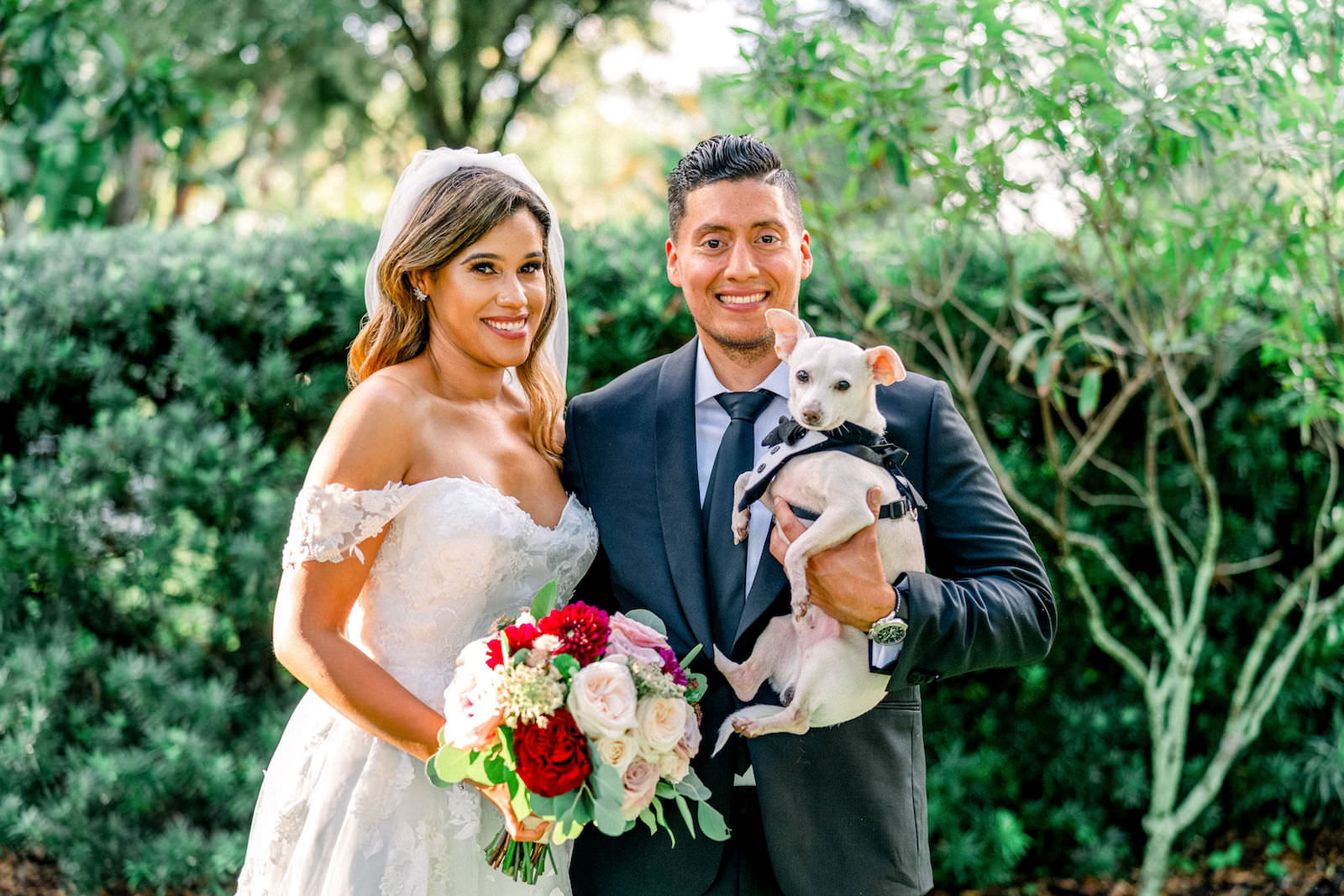 Bride and Groom Portrait with Pet Dog of Honor | Groom in Classic Black Suit Tux | Off The Shoulder Lace Applique Sweetheart Ballgown Wedding Dress | Ivory Blush Pink and Maroon Red Roses Bridal Bouquet | FairyTail Pet Care