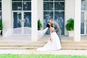 Romantic Creative Bride and Groom with Veil Blowing in the Wind First Look Wedding Portrait | Wedding Photographer Shauna and Jordon Photography | Wedding Venue Tampa Garden Club | Wedding Dress Truly Forever Bridal