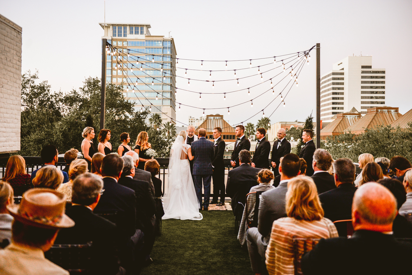 Black and White Outdoor Rooftop Wedding Ceremony with Edison Bulb Backdrop | Downtown St. Pete Wedding Venue Station House