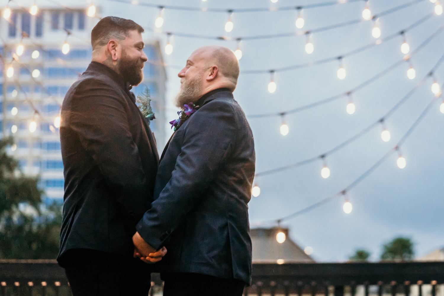 Same Sex Gay Tampa Grooms with Rooftop and String Lights Backdrop Wedding Portrait | St. Pete Unique Wedding Venue Station House