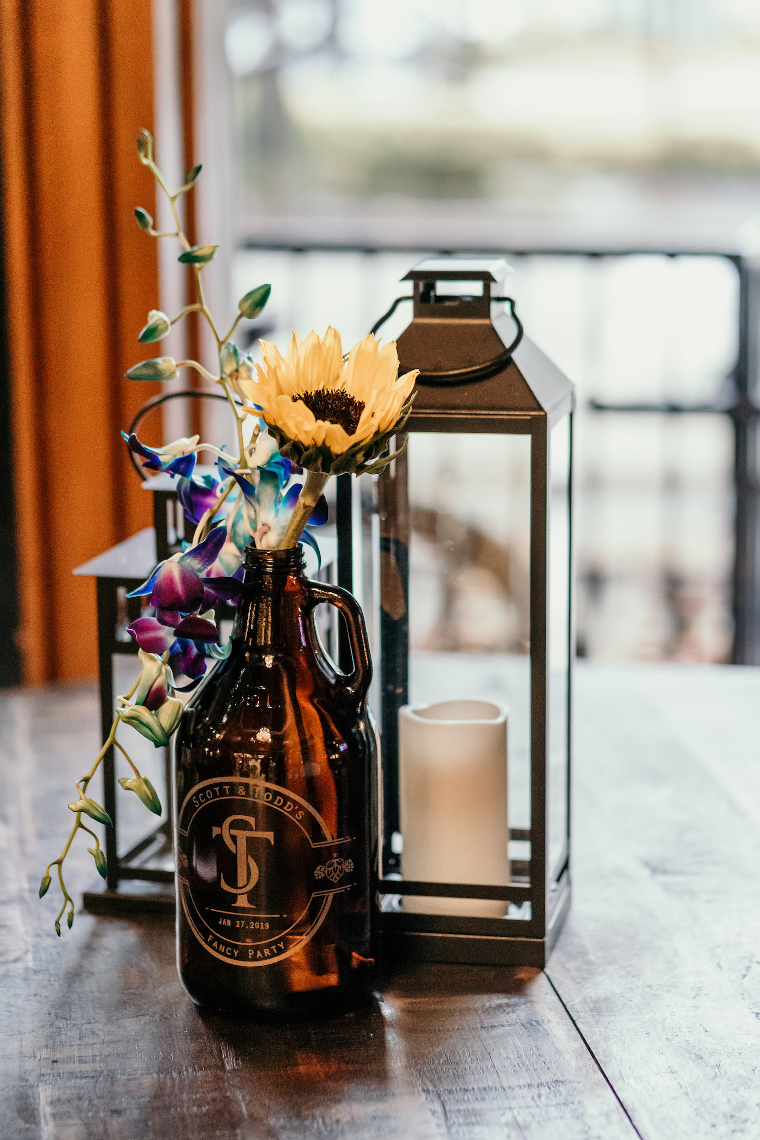 Minimalist Wedding Reception Decor, Black Lanterns and Custom Monogram Beer Growlers with Yellow Sunflower and Purple Orchids Floral Centerpiece