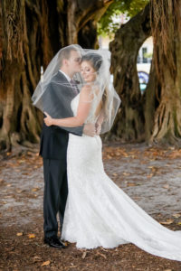 Creative Florida Bride and Groom Under Wedding Veil Embrace In Front of Banyan Trees in Straub Park Downtown St. Petersburg | Tampa Bay Hair and Makeup Artist Michele Renee The Studio | Florida Wedding Photographer Lifelong Photography Studio