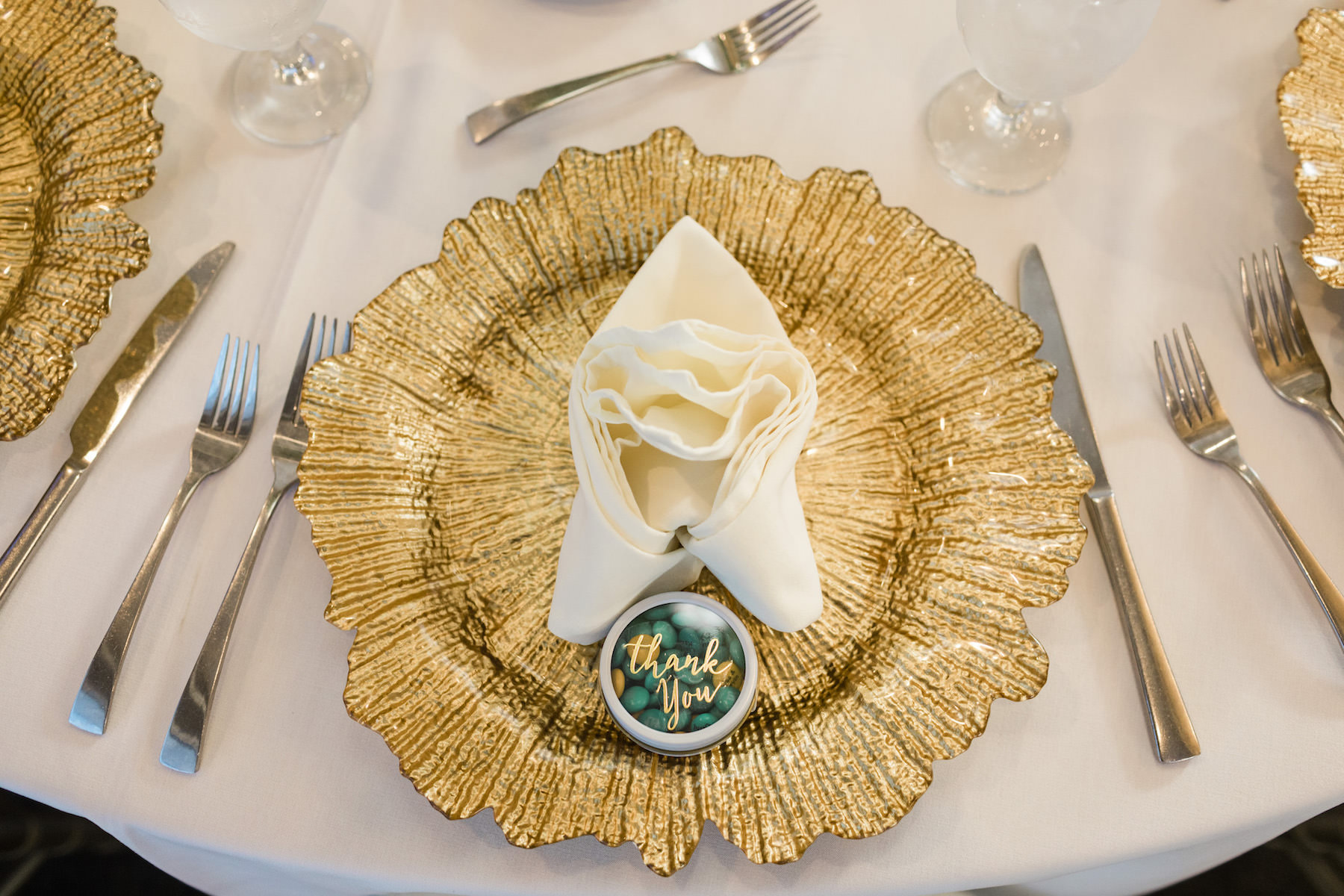 Wedding Place Setting with Gold Glass Charger Plate and Ivory Napkin and M&M Candy Favors