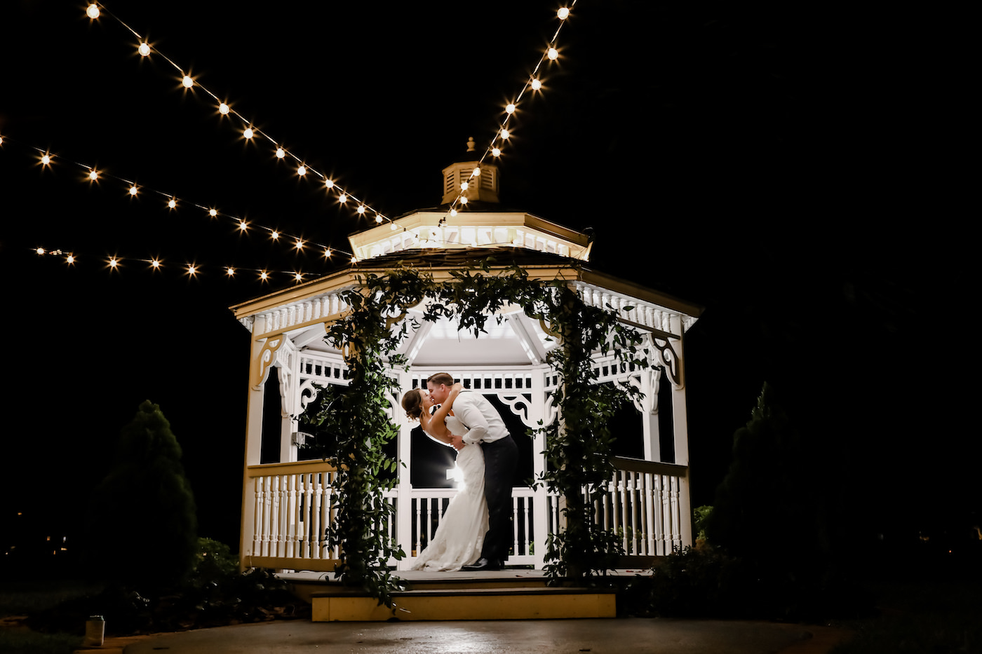 Romantic Intimate Bride and Groom NIghttime Wedding Portrait Under White Gazebo with Greenery Arch and String Lights | Wedding Photographer Lifelong Photography Studio | Tampa Wedding Planner Blue Skies Weddings and Events | Waterfront Wedding Venue Davis Islands Garden Club
