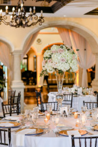 Tampa Wedding Venue Avila Golf & Country Club | Indoor Ballroom Reception with Chiavari Chairs and Chandeliers | White and Blush Dusty Rose | Tall Centerpiece with Hydrangea Roses and Greenery