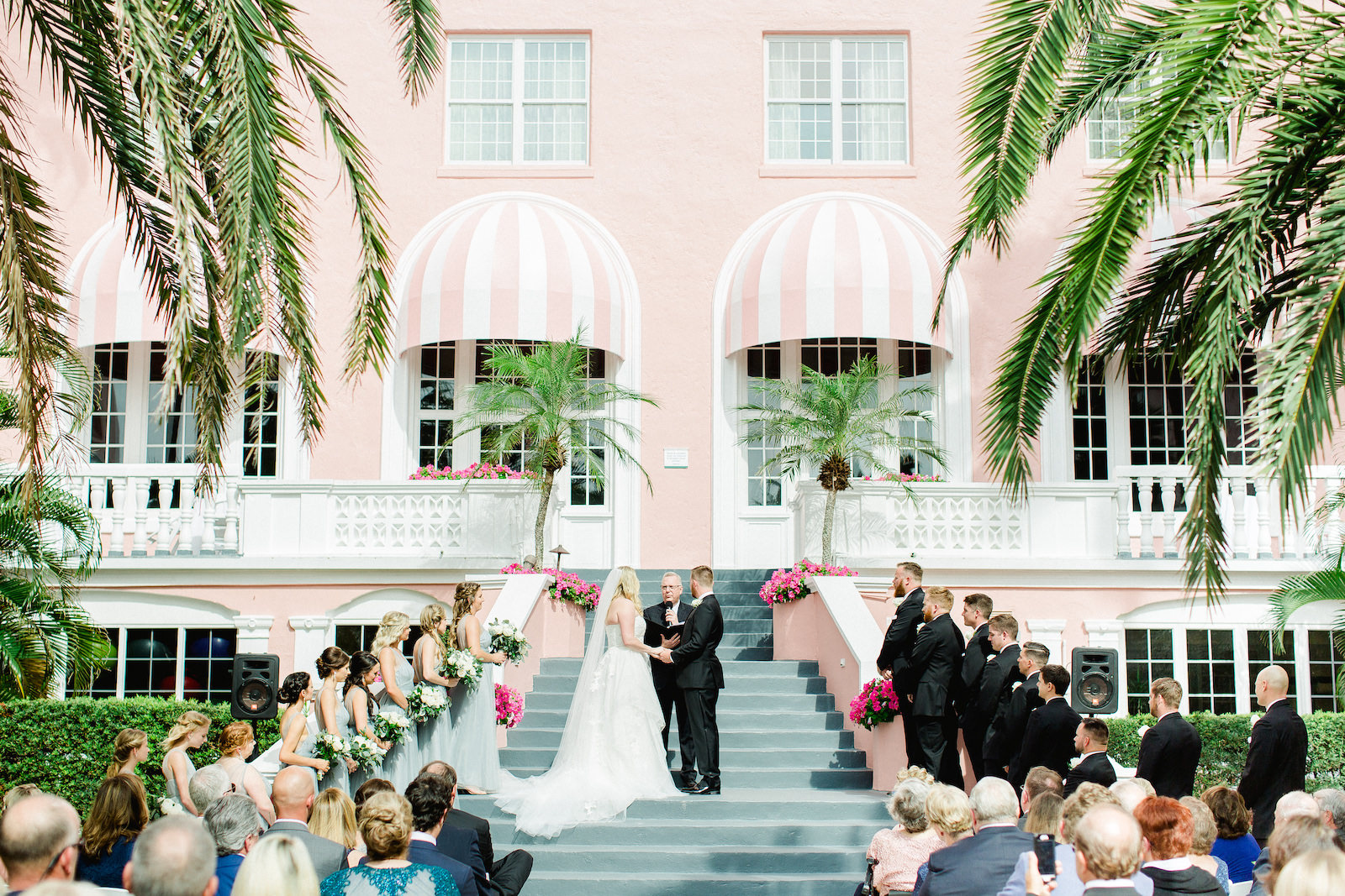 Staircase Wedding Ceremony | Dusty Blue Grey Tulle Bridesmaid Dresses | St Pete Beach Wedding Venue The Don Cesar | Classic Greenery White Flowers Bouquets | Groom Groomsmen Wearing Classic Black Suit Tux