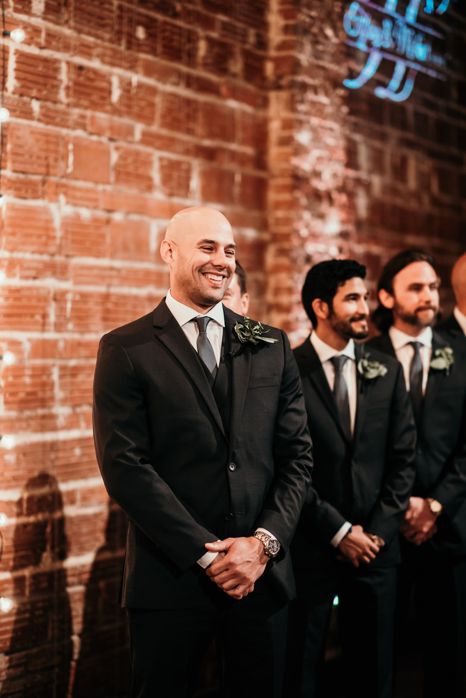 Tampa Bay Groom Smiles During Wedding Ceremony in front of Exposed Red Brick Wall | Unique Florida Industrial Wedding Venue NOVA 535