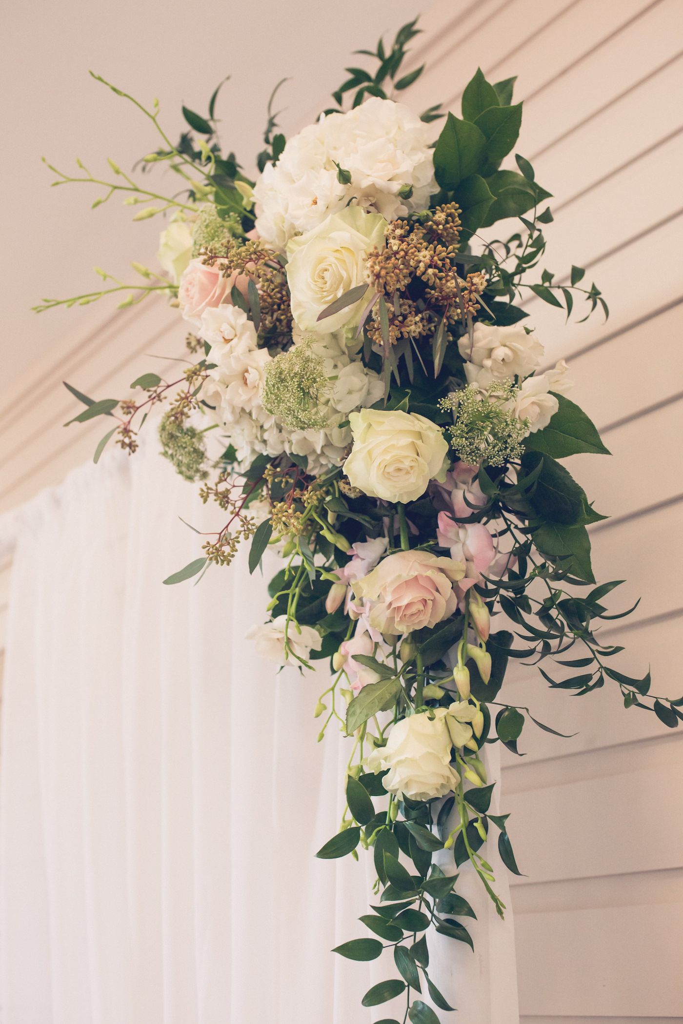 Ceremony Arch Floral Arrangement with Greenery and White Hydrangea and Ivory Roses with Seeded Eucalyptus and Blush Pink Orchids and Queen Anne Lace