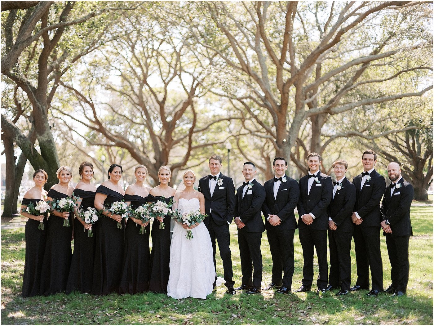 Wedding Party Outdoor Portraits | Black Long Bridesmaid Dresses with Black and White Anemone and Greenery Bouquets | Groomsmen Classic Black Suit Tuxedo with Bow Tie | Tampa Bridesmaids Dress Store Bella Bridesmaids