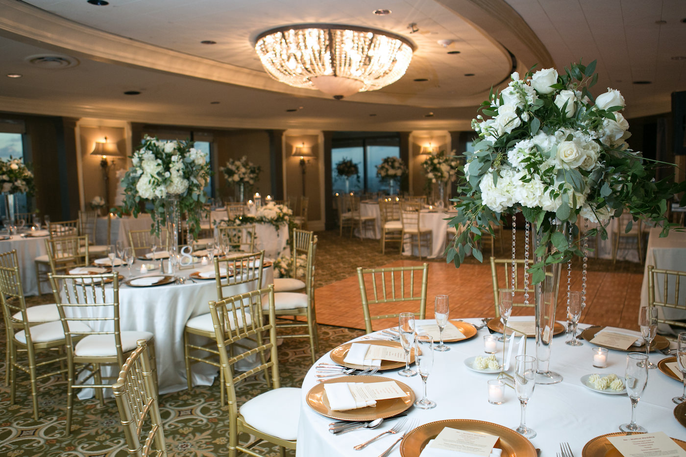 Romantic Classic Wedding Reception Decor, Round Tables with Gold Chiavari Chairs, Tall White Hydrangeas and Roses with Greenery and Hanging Crystals Floral Centerpieces, Gold Chargers | Wedding Photographer Carrie Wildes Photography | Ballroom Wedding Venue The Tampa Club