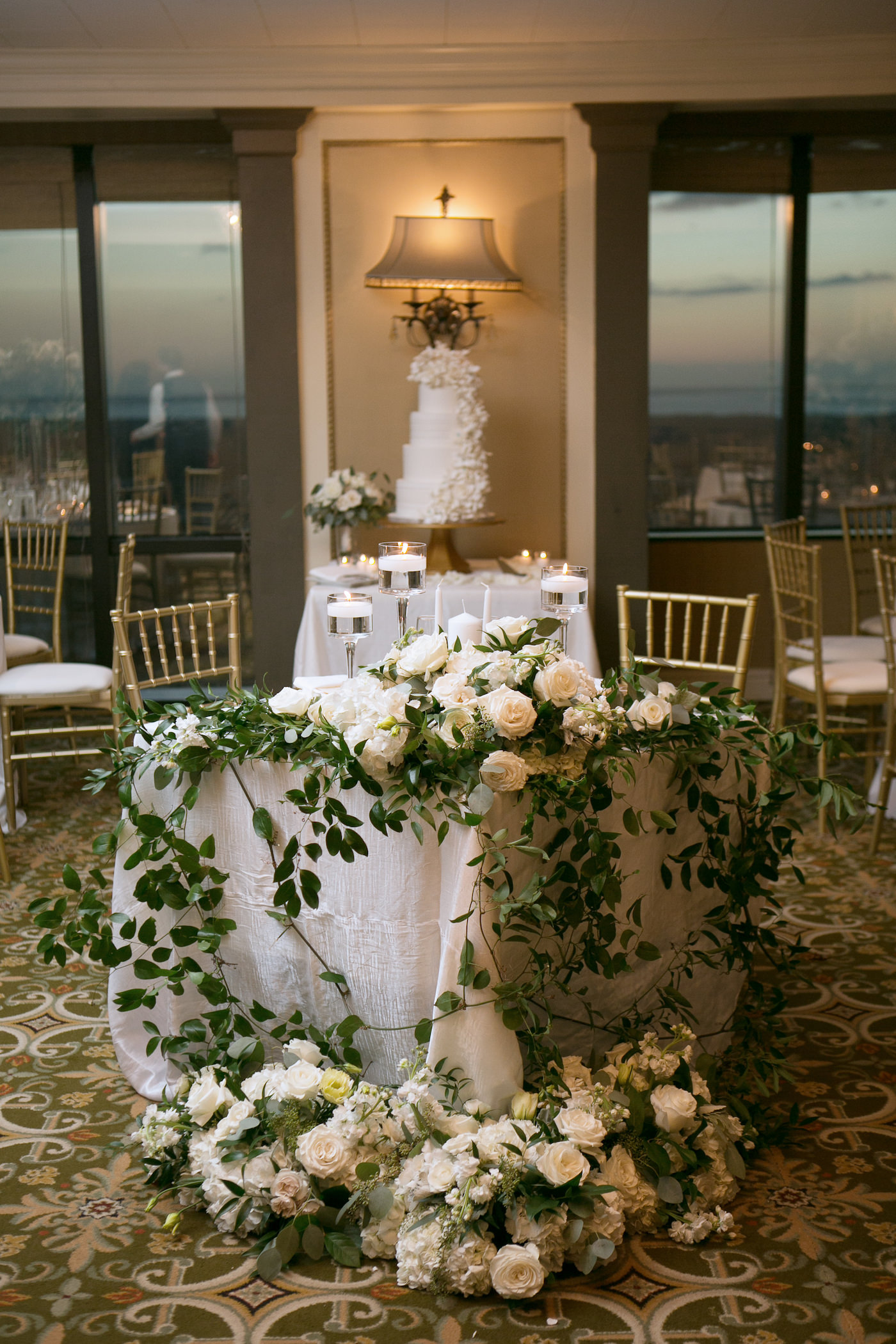 Classic Timeless Wedding Reception Decor, Sweetheart Table with White Linen, Whimsical Greenery Leaves and Vines with White Roses, Hydrangeas Florals, Tall Floating Candlesticks, Gold Chiavari Chairs | Wedding Photographer Carrie Wildes Photography | Ballroom Wedding Venue The Tampa Club