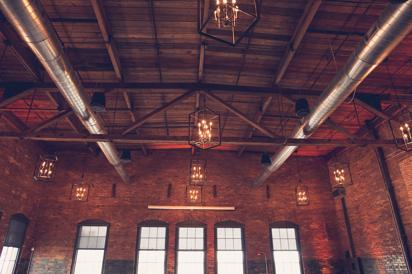 Tampa Wedding Historic Venue Armature Works Unique Architecture with Brick Walls and Exposed Beam ceilings with Edison Bulb Chandeliers