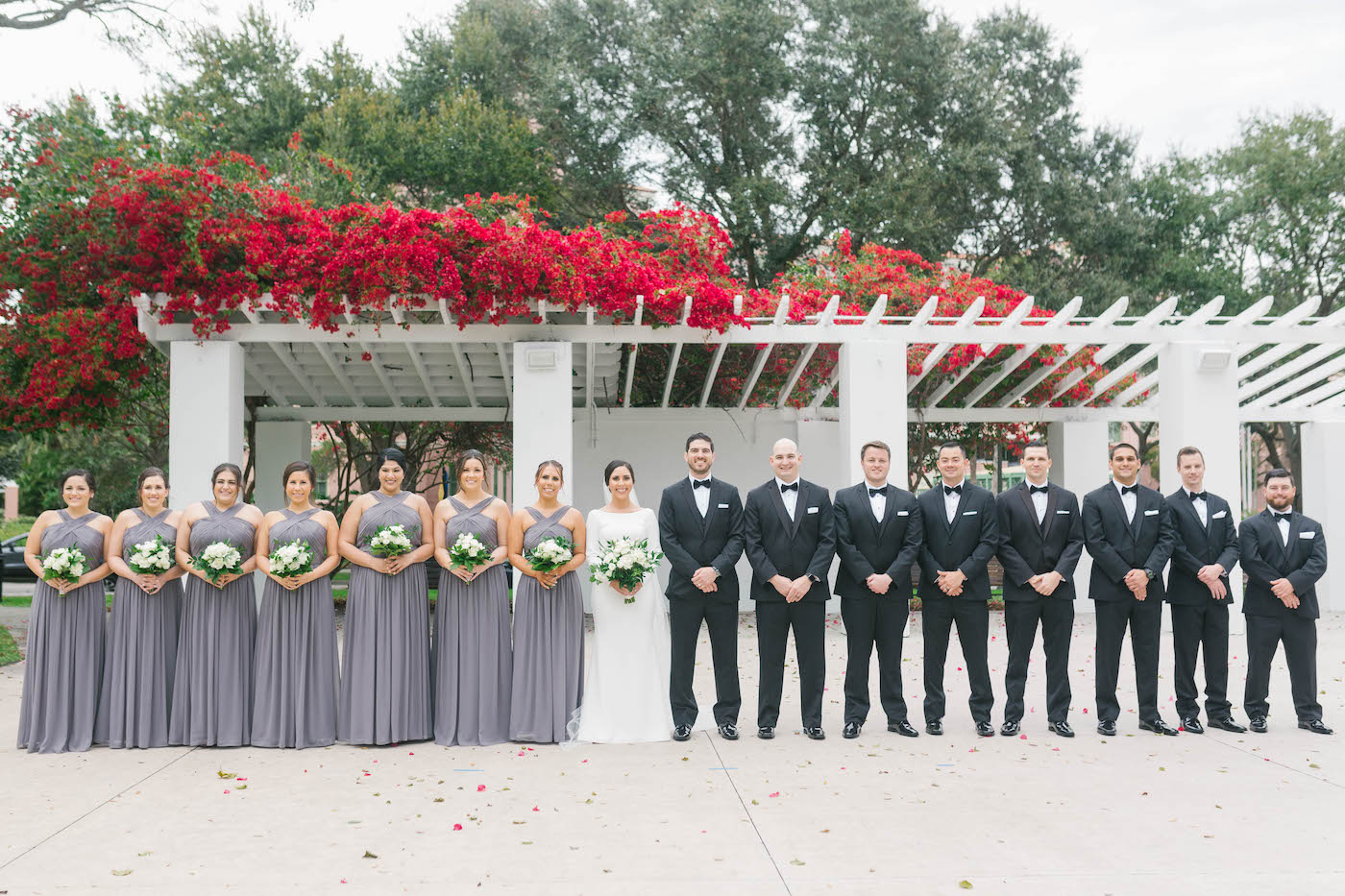 Florida Wedding Party Portrait, Classic Groomsmen in Black Tuxedos, Bridesmaids Wearing Matching Long Dark Slate Gray Watters Dresses, Bride Wearing Timeless White Mikaella Bridal Wedding Dress, Holding Ivory and White Floral Bouquet | Tampa Bay Wedding Planner Parties A'La Carte | Downtown St. Pete Wedding Florist Bruce Wayne Florals